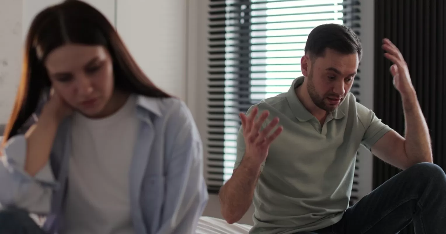 A couple sitting in silence, highlighting avoidance of difficult conversations in their relationship