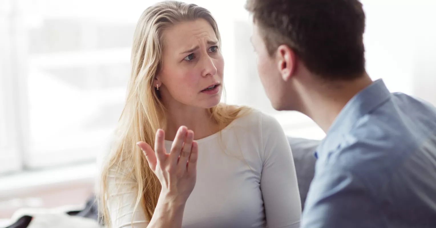 Individual experiencing insecurity while observing partner talk to an attractive person