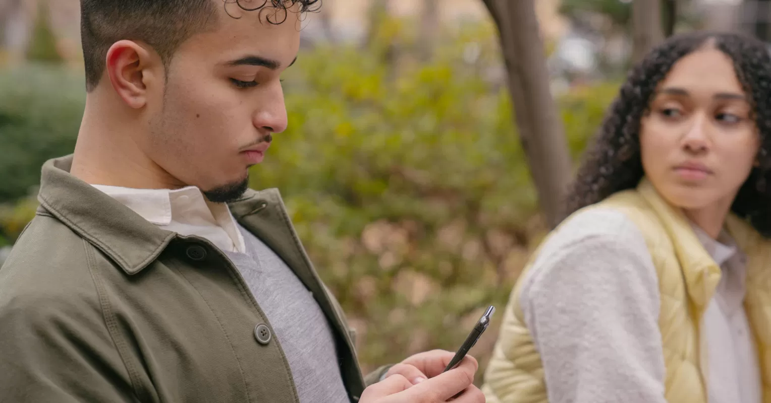 Individual feeling insecure while watching their partner socialize with friends, revealing relationship signals