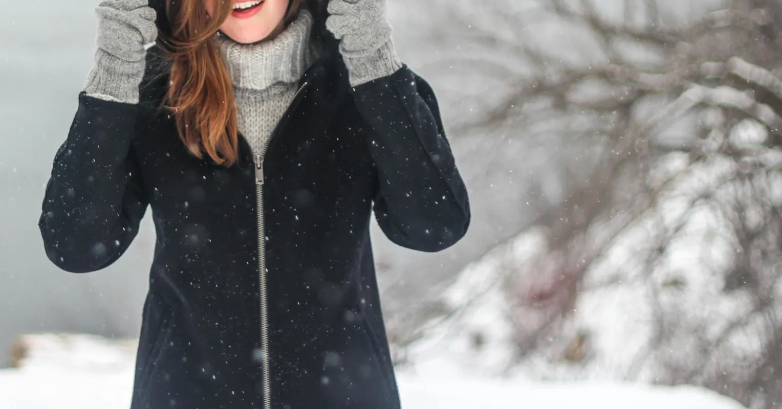 Person contemplating seasonal emotions while receiving a text from an ex in winter