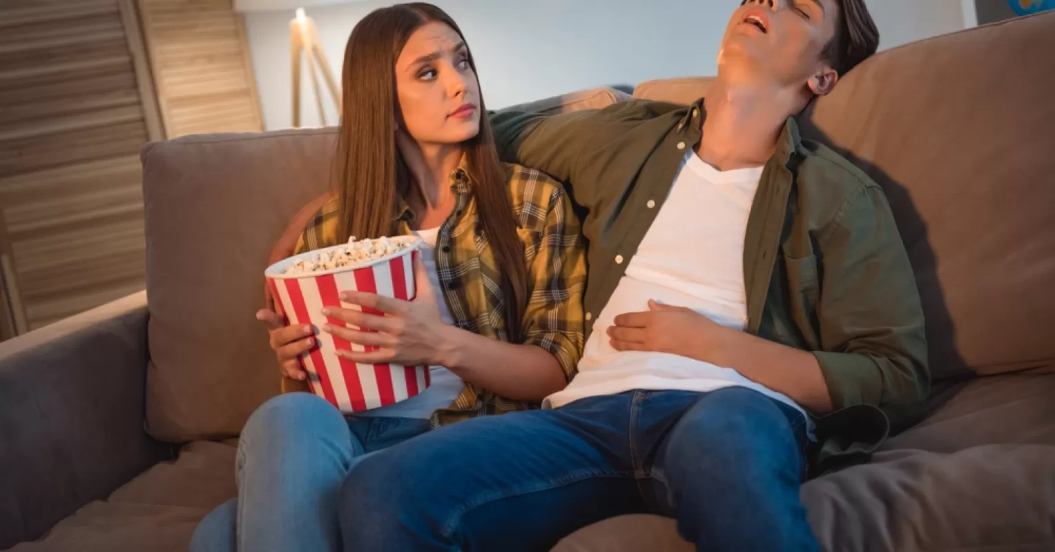Couple enjoying a quiet evening, one partner falling asleep during quality time together.