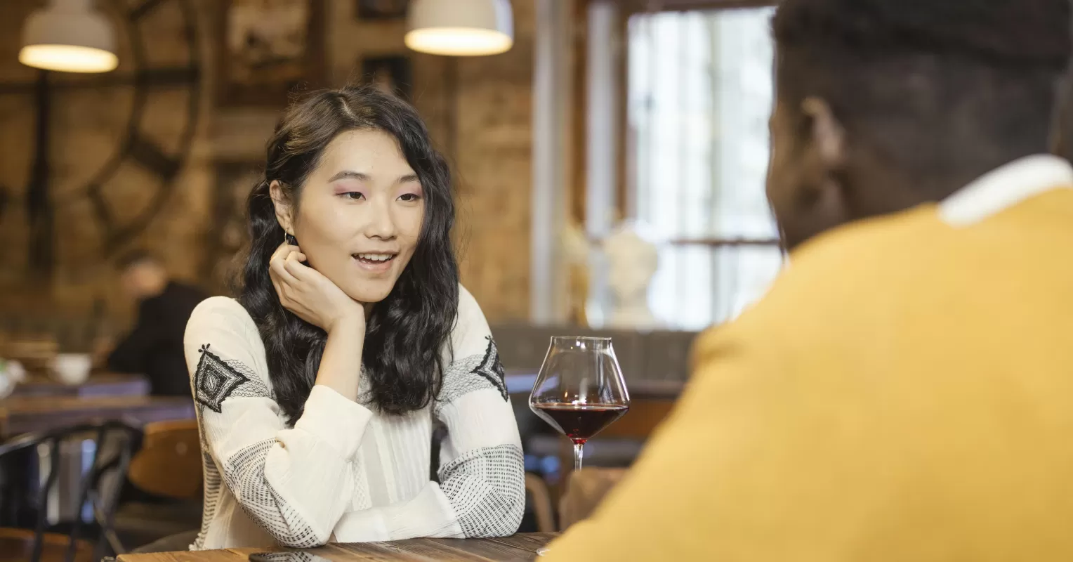 Young couple experiencing pressure to rush intimacy during a romantic dinner