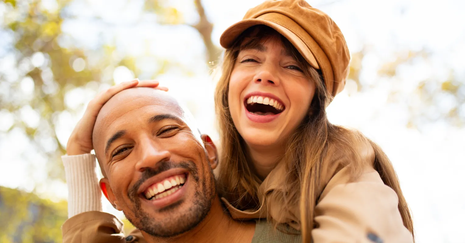 Couple sitting apart on a couch, feeling distant during colder months in a relationship