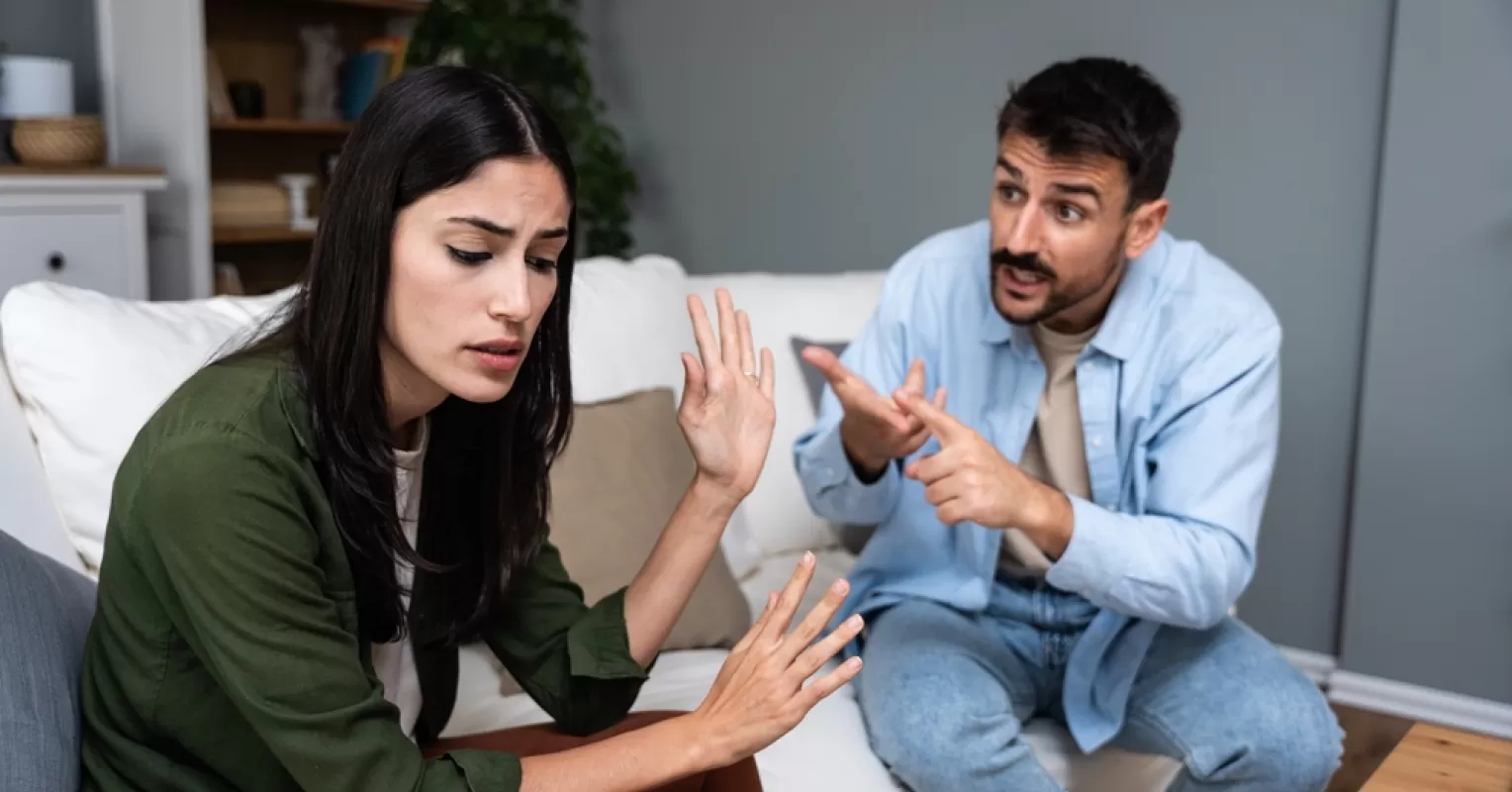 A couple sitting in silence, highlighting emotional distance after a disagreement