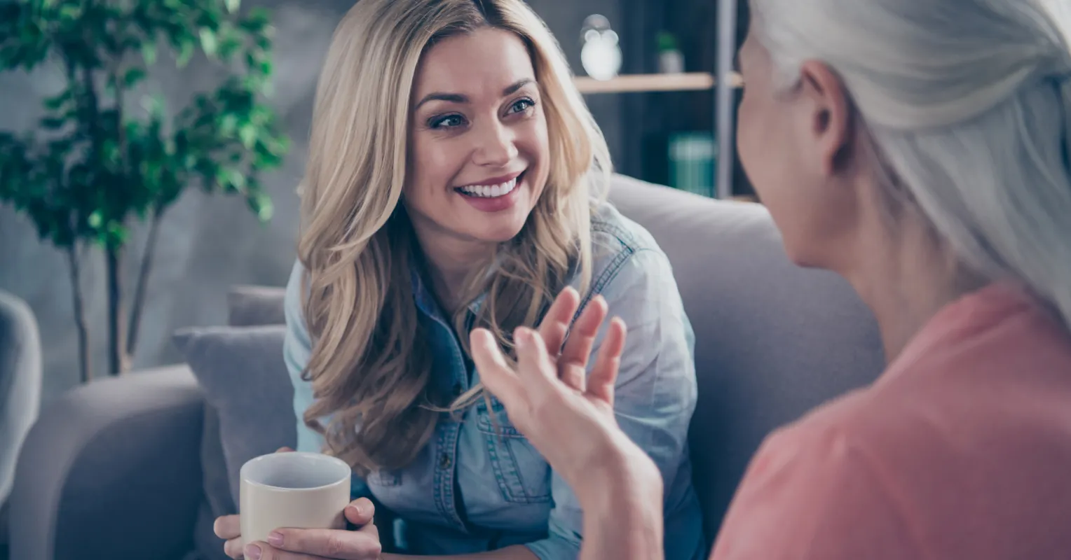 Mentor and mentee sharing smiles during a casual conversation, enhancing their mentoring relationship