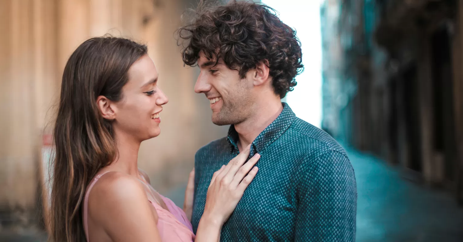 A couple exchanging playful glances, indicating how to tell if someone is flirting with you