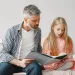 A stepchild looking contemplative while receiving support from their step-parent after feeling rejected