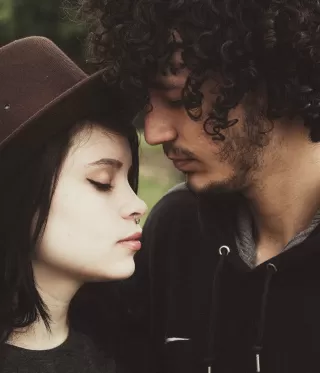 Couple discussing feelings of betrayal and trust signals in a warm, intimate setting