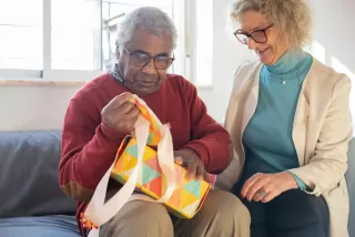Person experiencing discomfort while receiving an unwanted gift during a special occasion