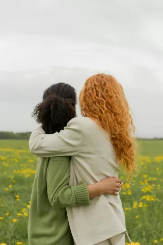 Two friends comforting each other while sharing emotional experiences and healing