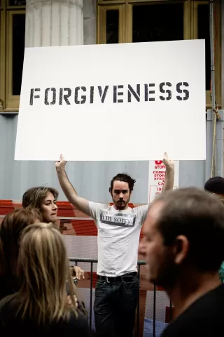 Couple facing each other, contemplating the difficulty of forgiveness in relationships.