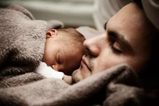 A man attentively caring for his partner during her pregnancy, reflecting shared emotional experiences.