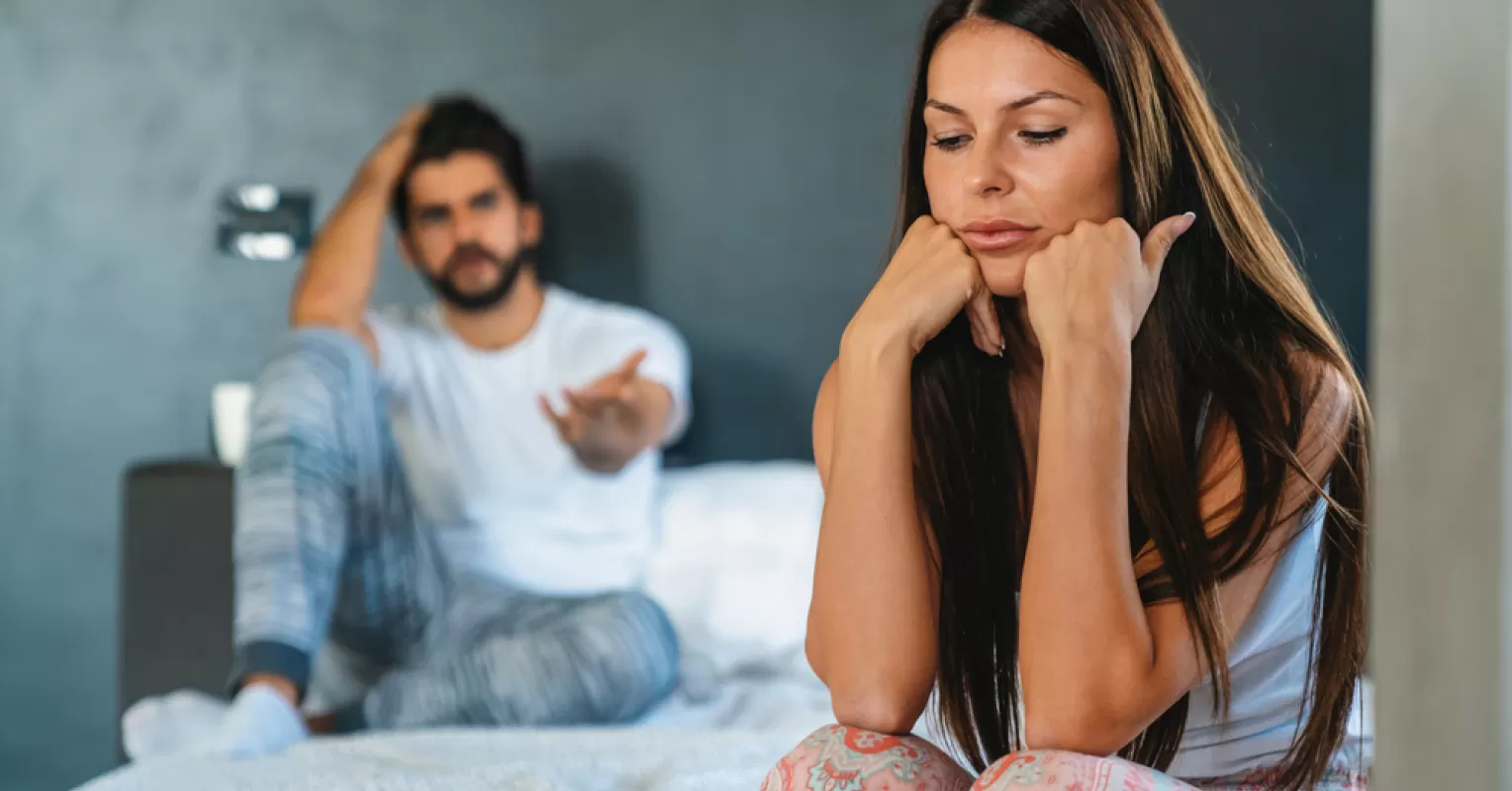 Couple sitting apart, showcasing signs of disconnection and unfulfillment in a relationship