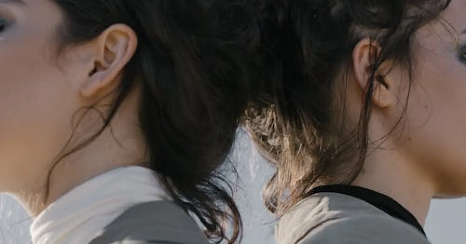 Twins enjoying a close moment, reflecting on the idealization of their twin relationship.