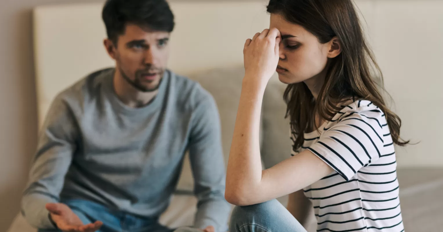 Couple sitting apart, exhibiting signs of emotional withdrawal in their relationship