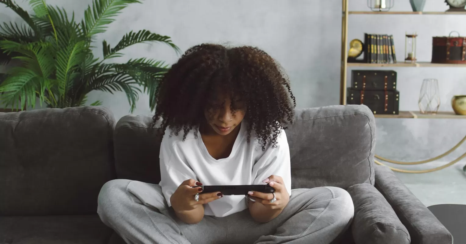 Individual smiling while engaging in an online friendship, revealing idealization signs