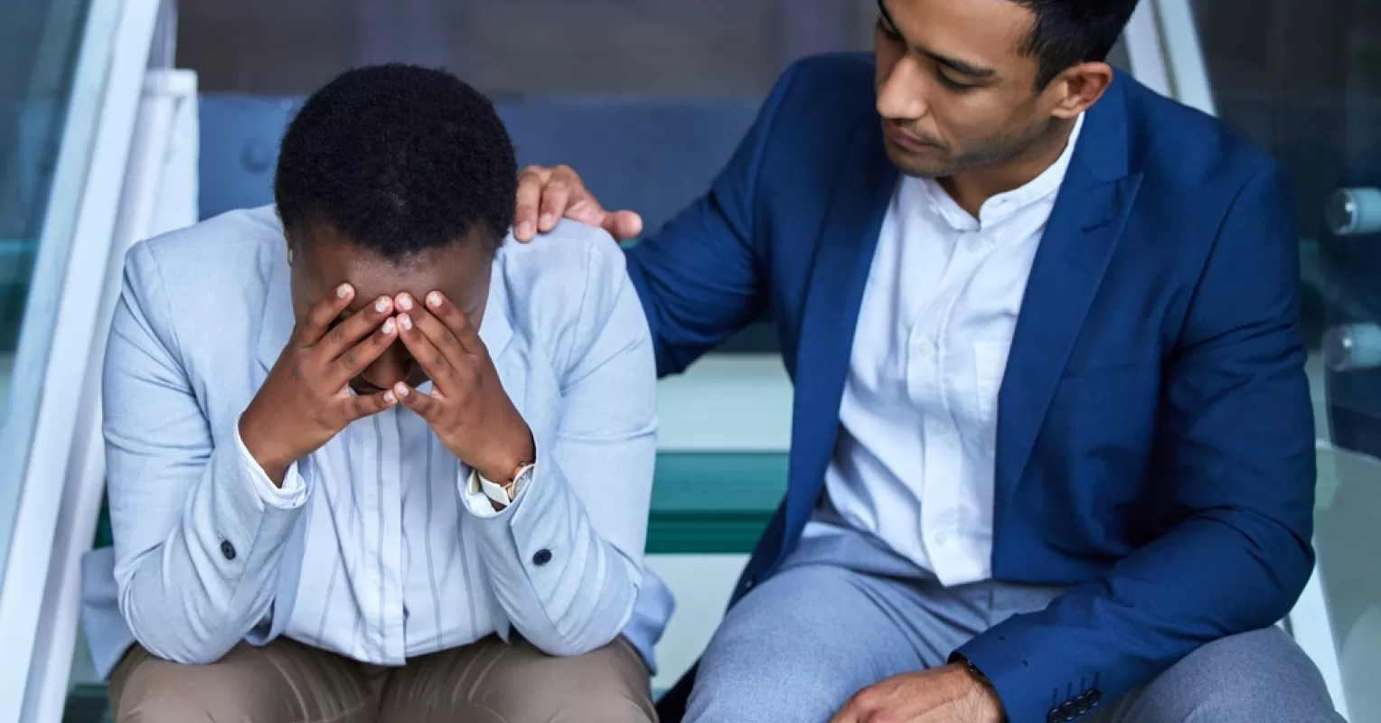 A supportive friend comforting another during moments of grief, highlighting empathy in tough times.
