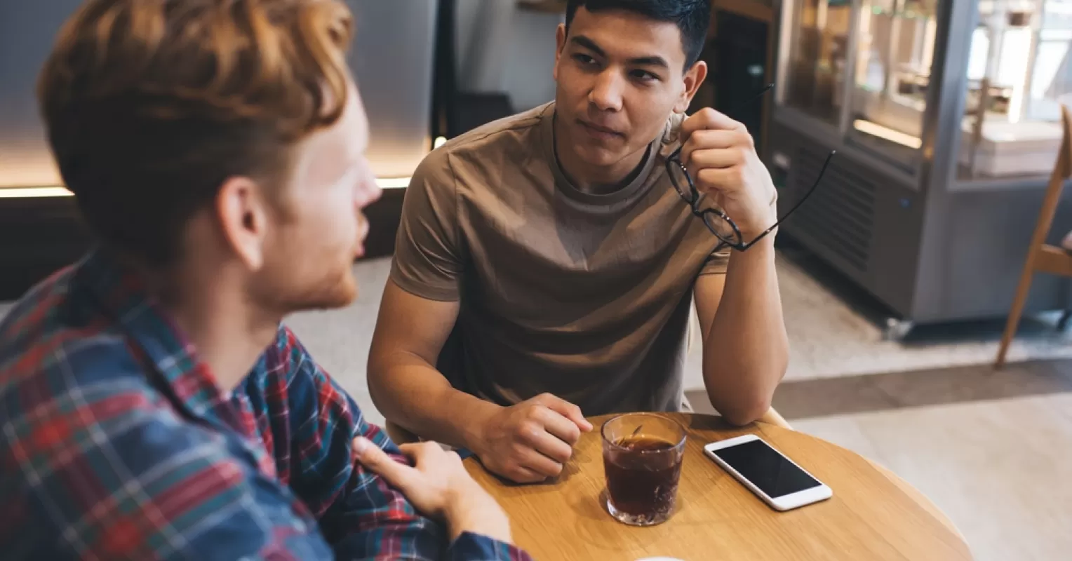 Individual experiencing anxious thoughts while interacting with a group of people