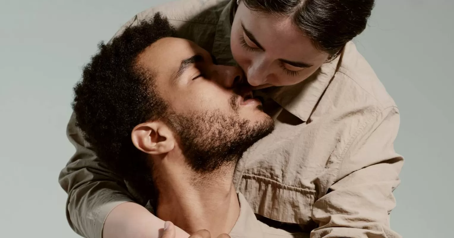 Person experiencing mixed emotions while receiving affection from a partner