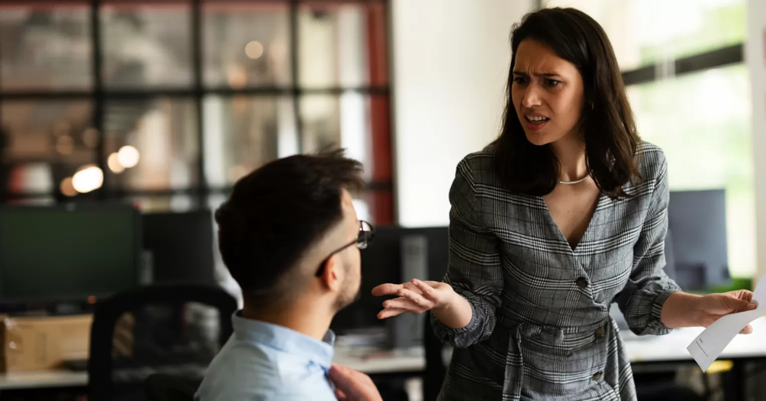 Colleagues whispering in the office, highlighting social dynamics and workplace gossip reasons