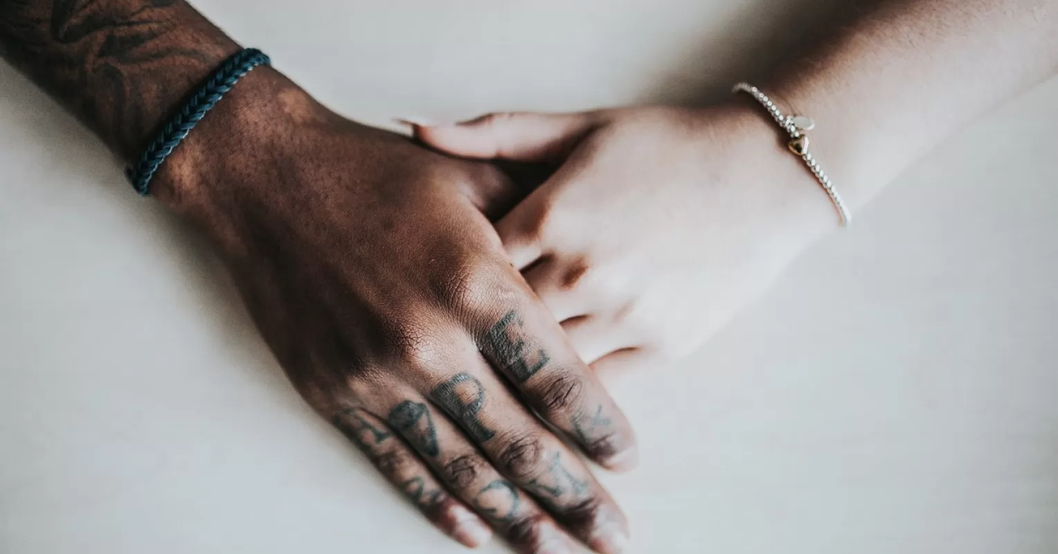 A couple sitting together yet appearing emotionally distant, illustrating struggle to connect with each other.