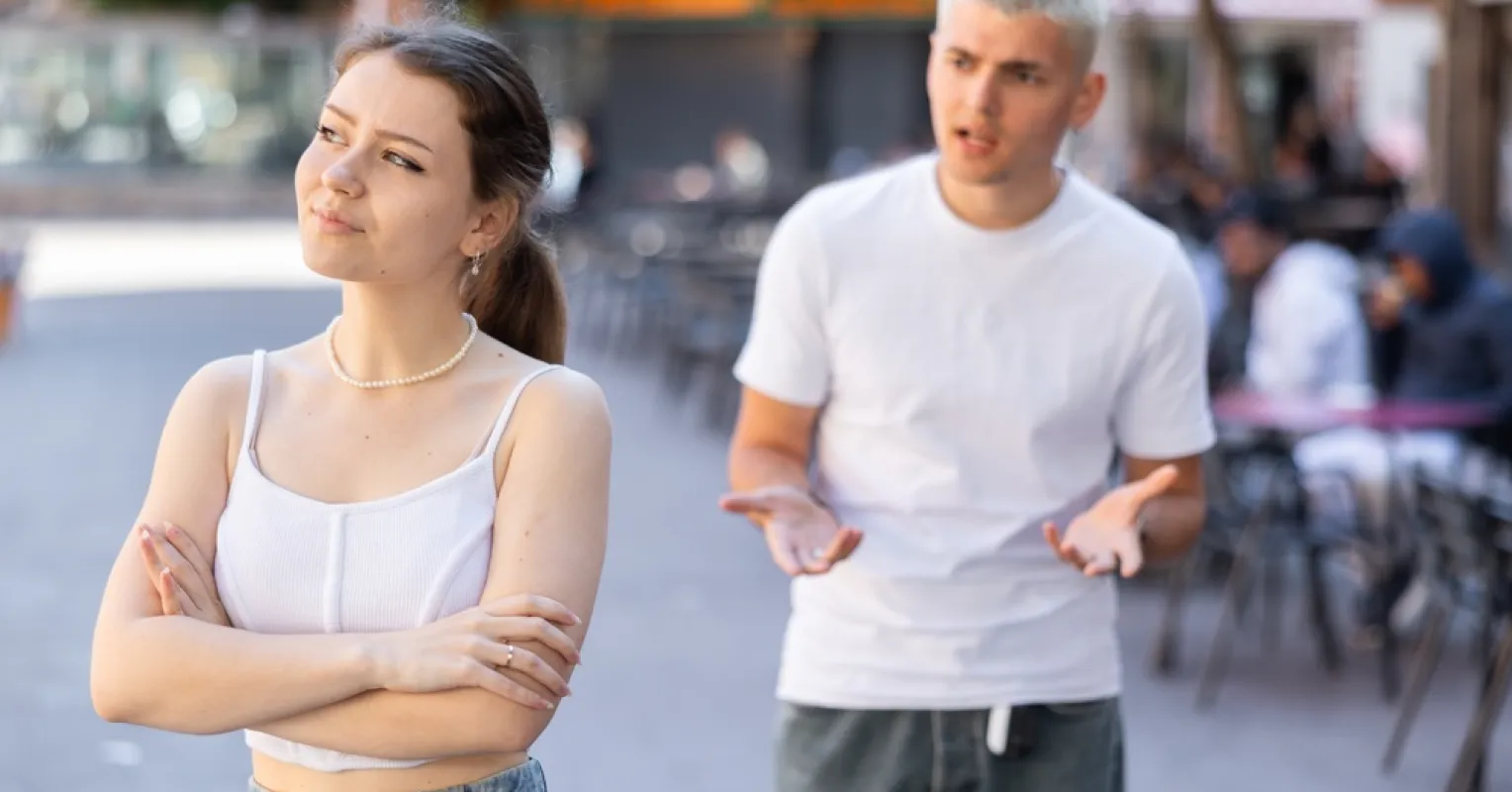 Individual contemplating commitment fears while observing a couple enjoying their relationship