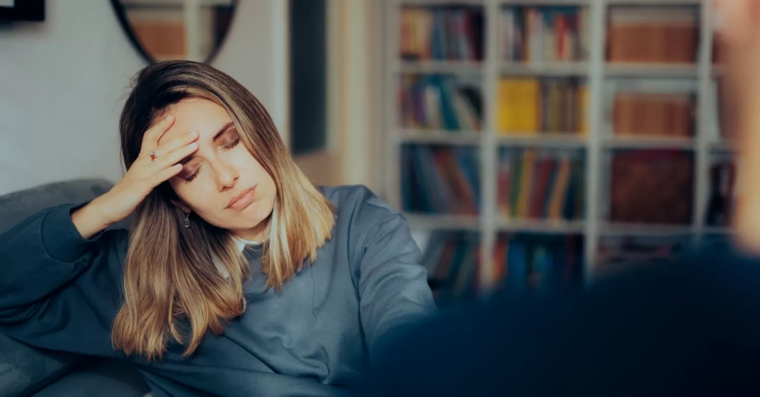 A person looking thoughtfully at a heart-shaped object, contemplating how to mend a broken heart.