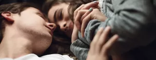 Couple sitting apart, reflecting on why they stay in unhappy marriages despite emotional disconnect