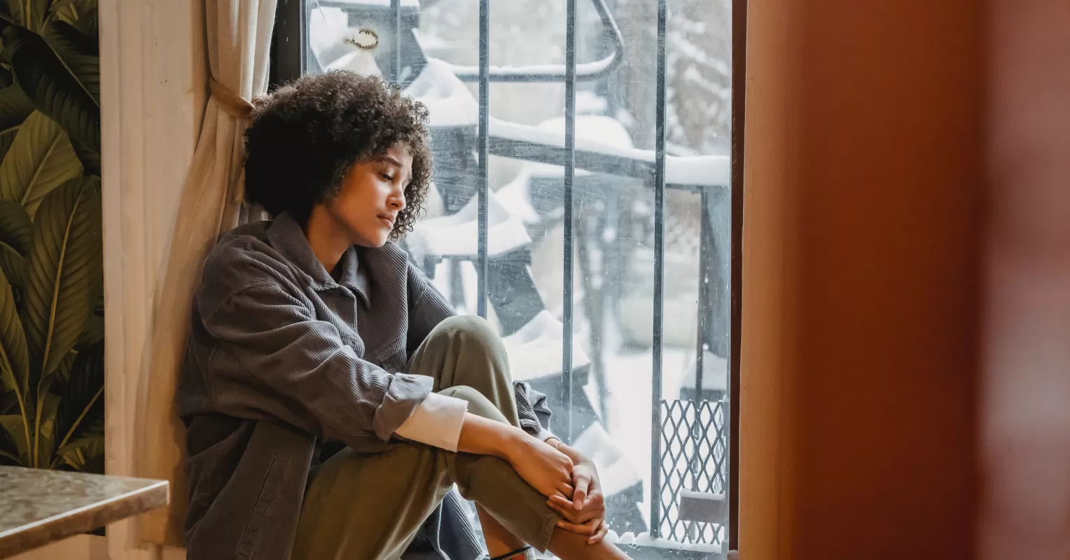 Individual sitting alone, contemplating the emotional effects of ghosting on mental health