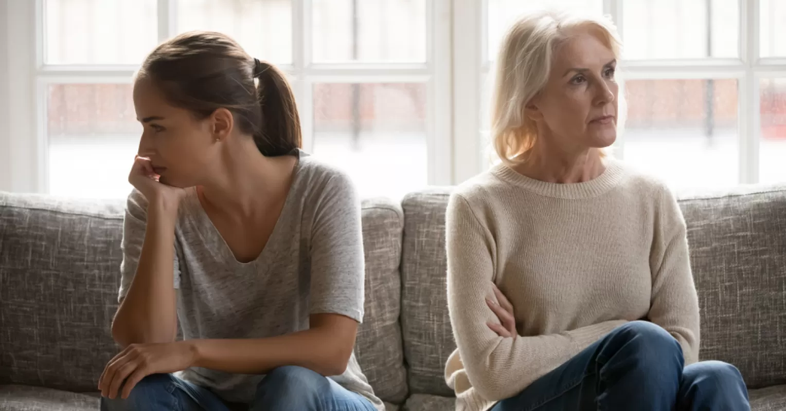 Daughter feeling overwhelmed by her mother's critical remarks during a conversation