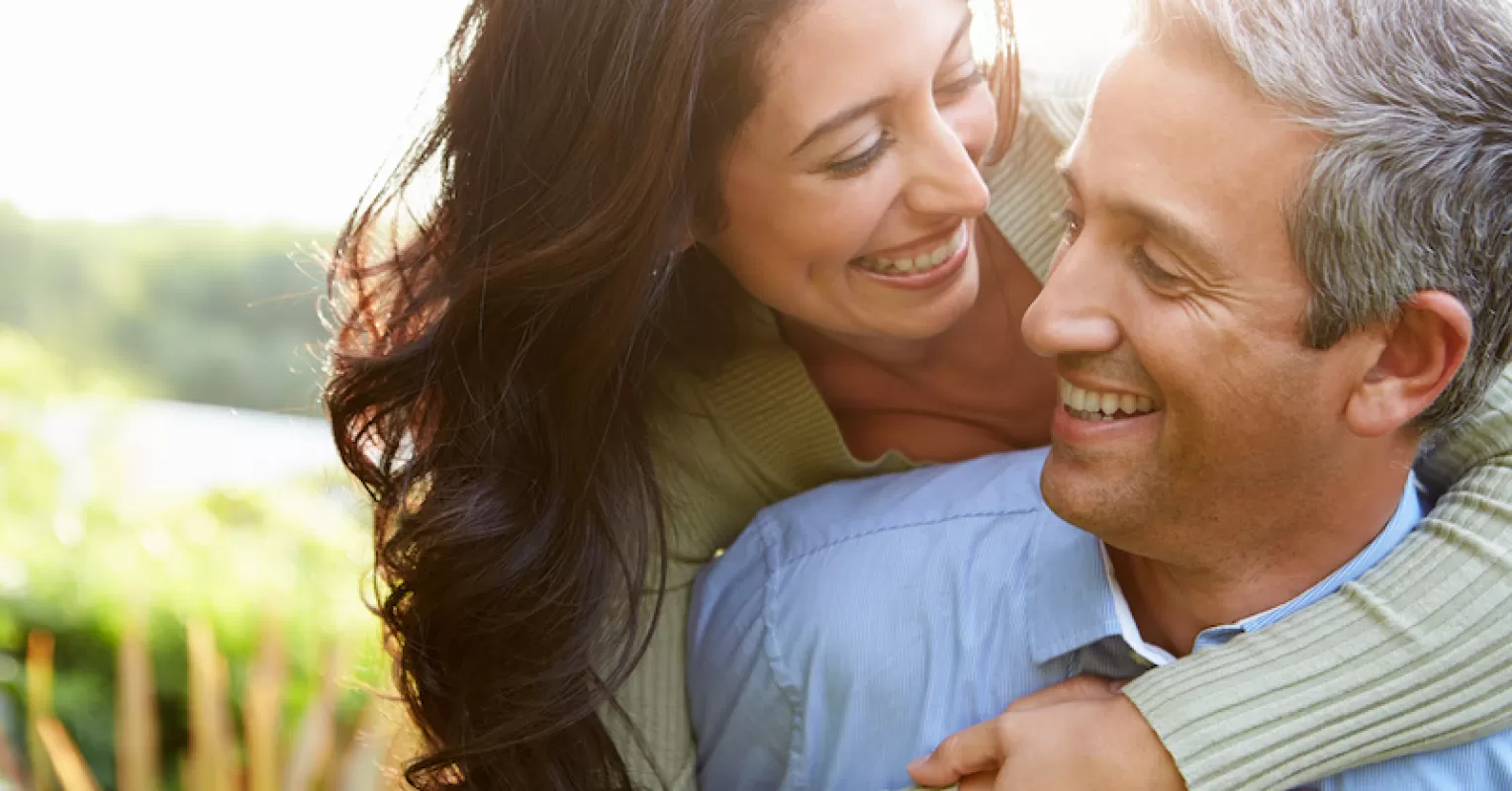 Individual contemplating feelings of unworthiness while observing a couple's affectionate interaction
