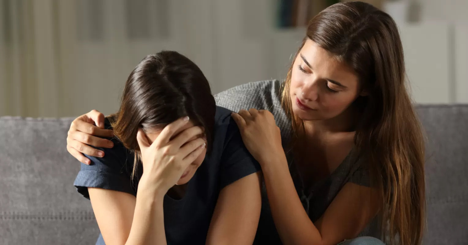 A supportive friend comforting someone feeling hopeless, highlighting relationship signals of distress