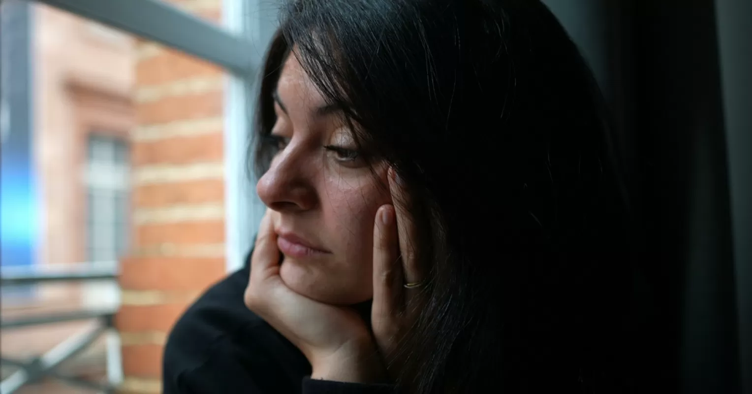 Individual contemplating signs of mind games in a relationship, feeling uncertain and confused
