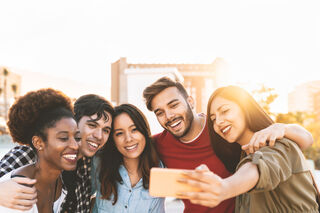 Introvert engaging in conversation, signaling openness to friendship in a crowded setting