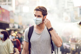 Individual wearing a mask, reflecting on the deeper meanings of human behavior and social signals.