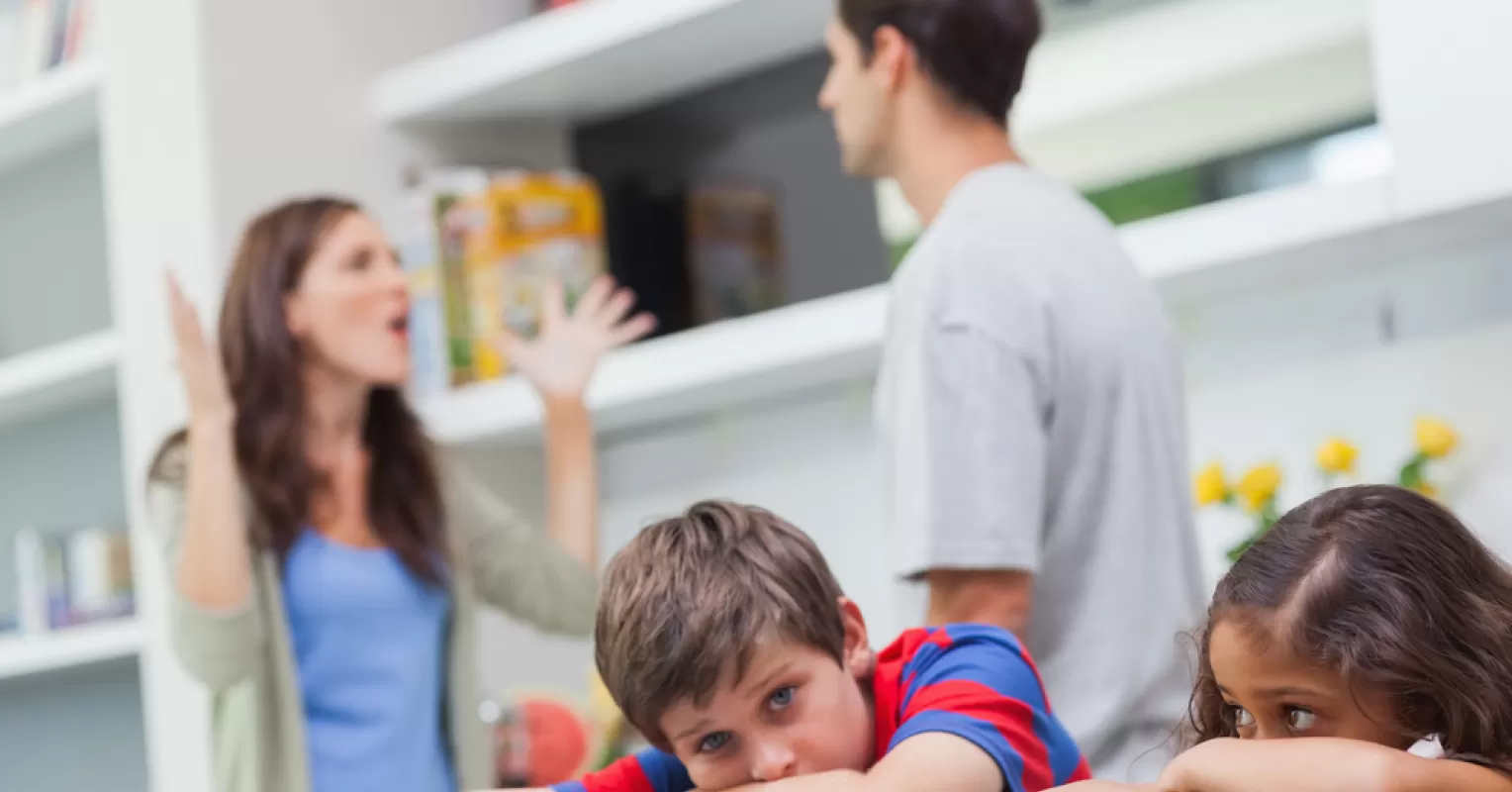A family sitting together but showing signs of emotional disconnect, reflecting on dysfunctional family dynamics.