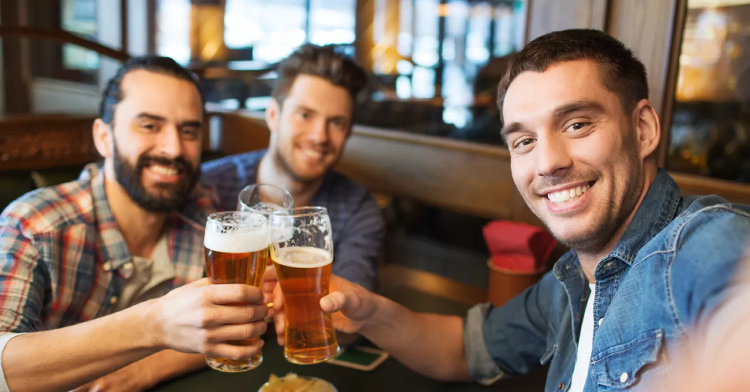 Individual standing apart in a social gathering, feeling out of place among others