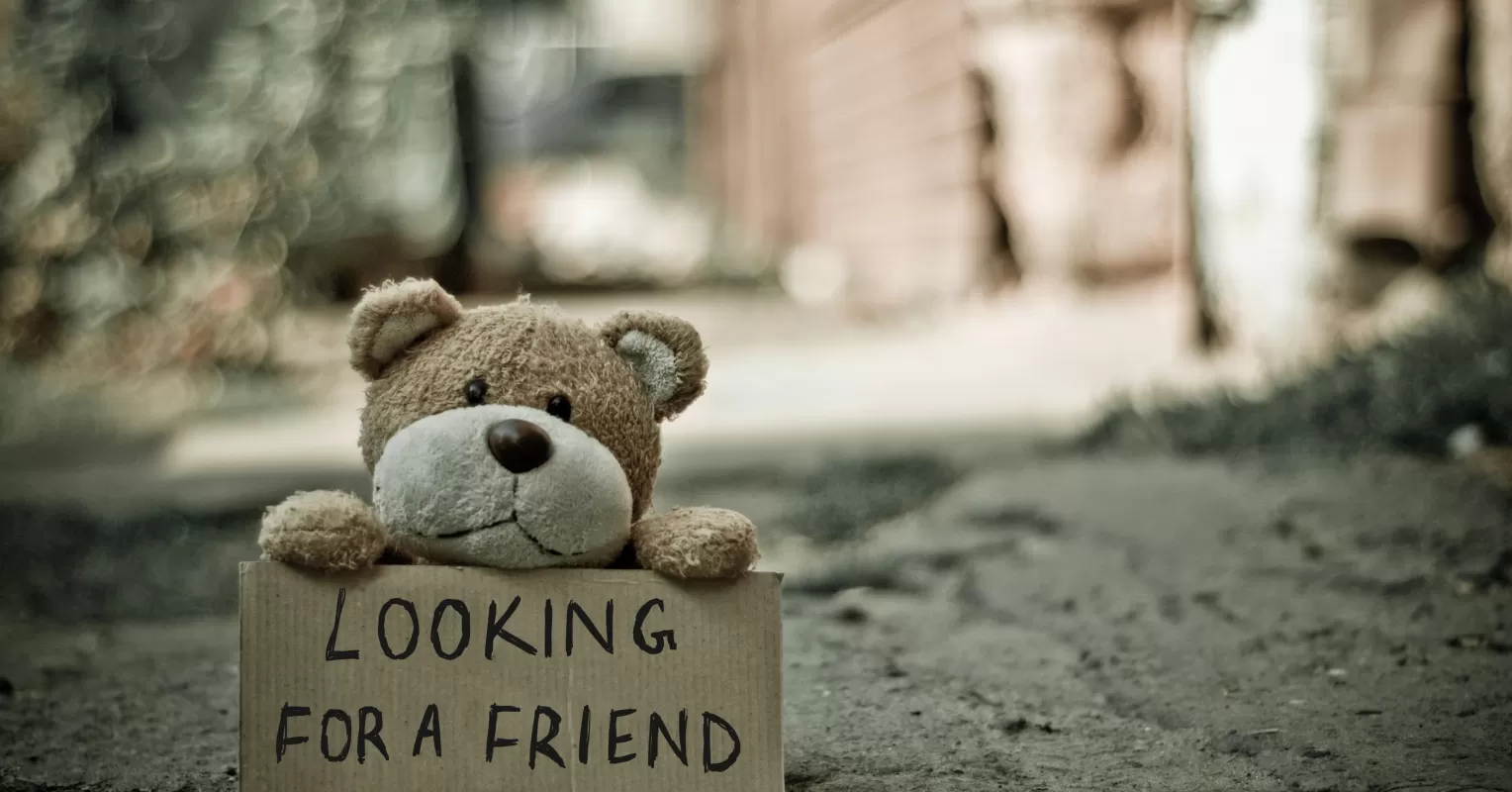 Person sitting alone in a crowded café, feeling lonely despite having friends nearby