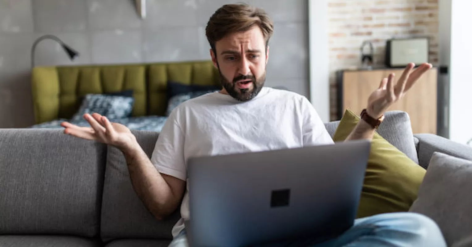 Employee managing anger in a tense workplace environment with colleagues nearby
