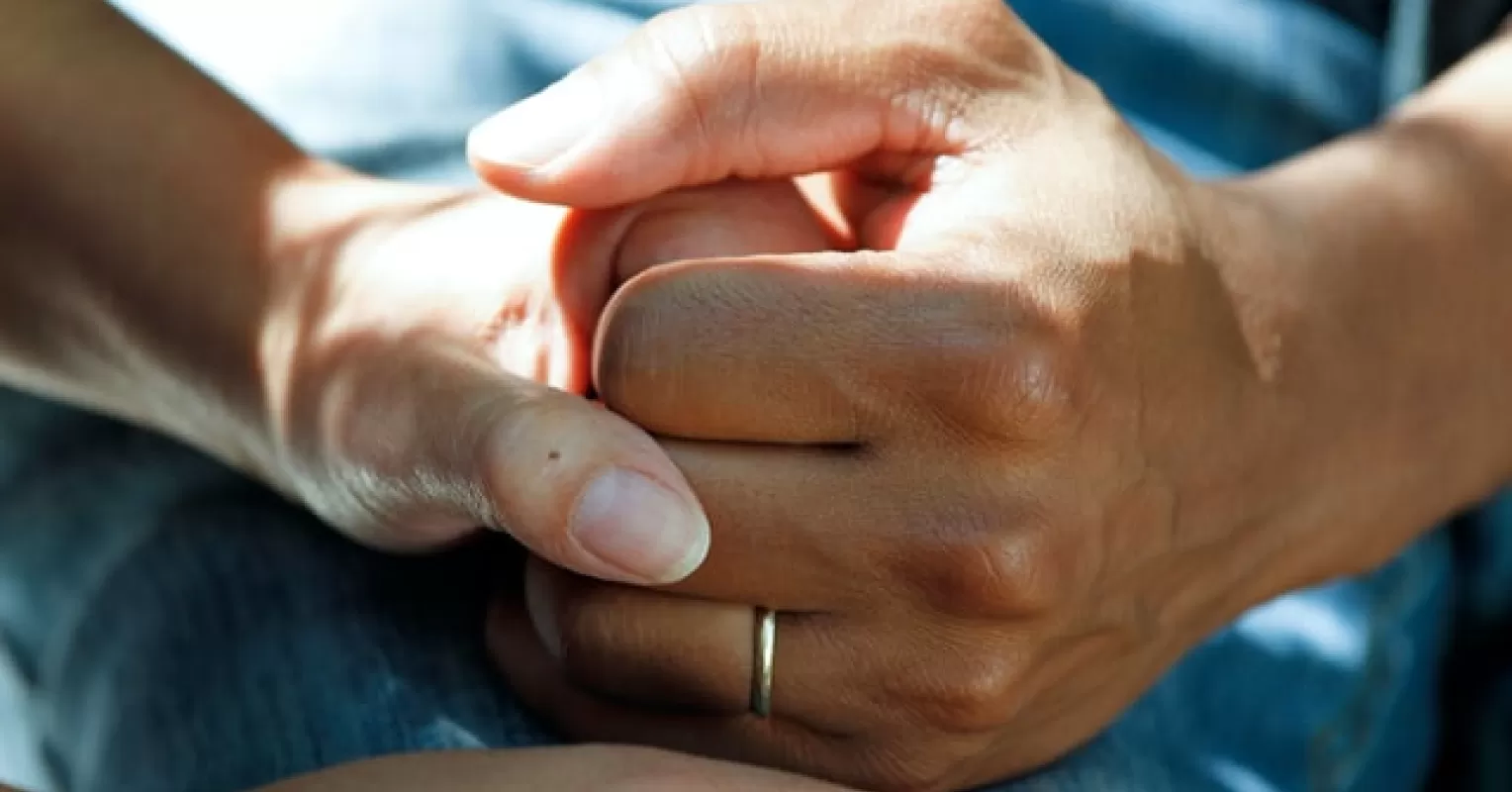 A comforting gesture between friends highlights social dynamics in supporting someone dealing with grief