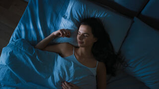 Person pondering the meaning of dreams about sex and their relationship signals