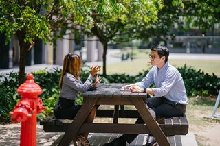 Individual experiencing discomfort in a social gathering, reflecting on why they feel awkward in social situations