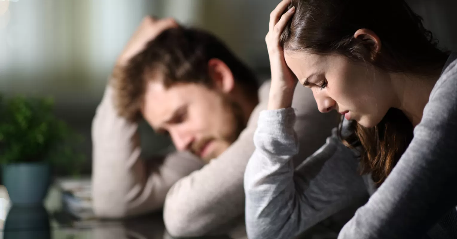 Individual feeling isolated while family members engage in joyful conversation, exploring black sheep dynamics
