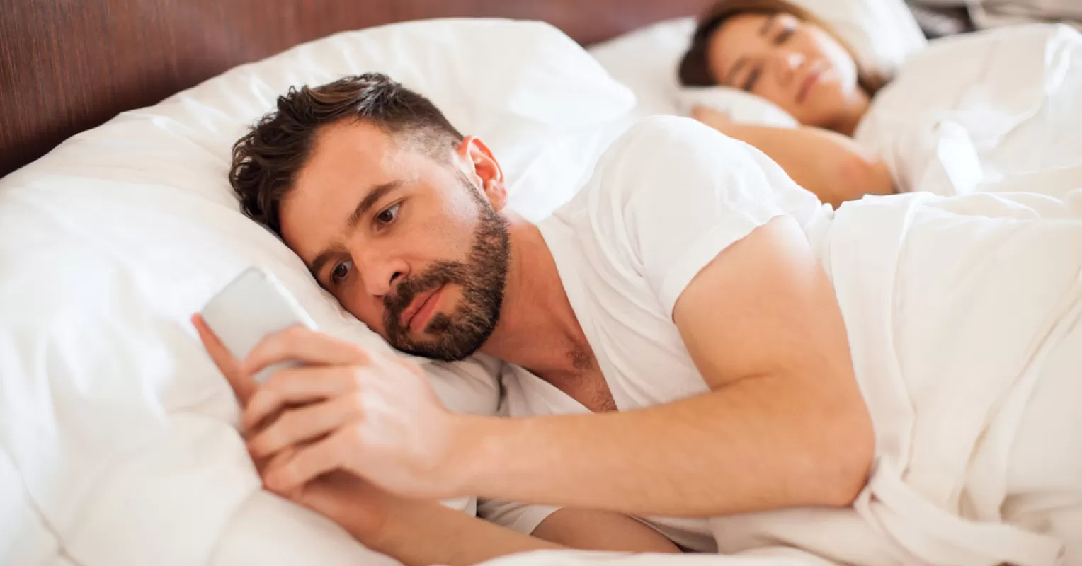 Man contemplating the emotional impact of infidelity and what it means when a man cheats