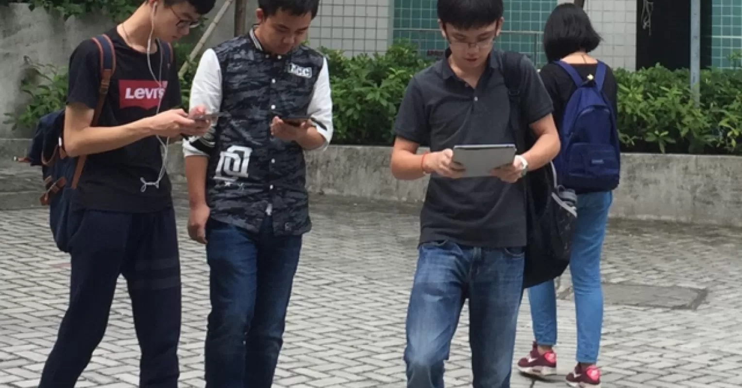 Teenager engrossed in smartphone, illustrating signs of social media addiction and its impact on social dynamics